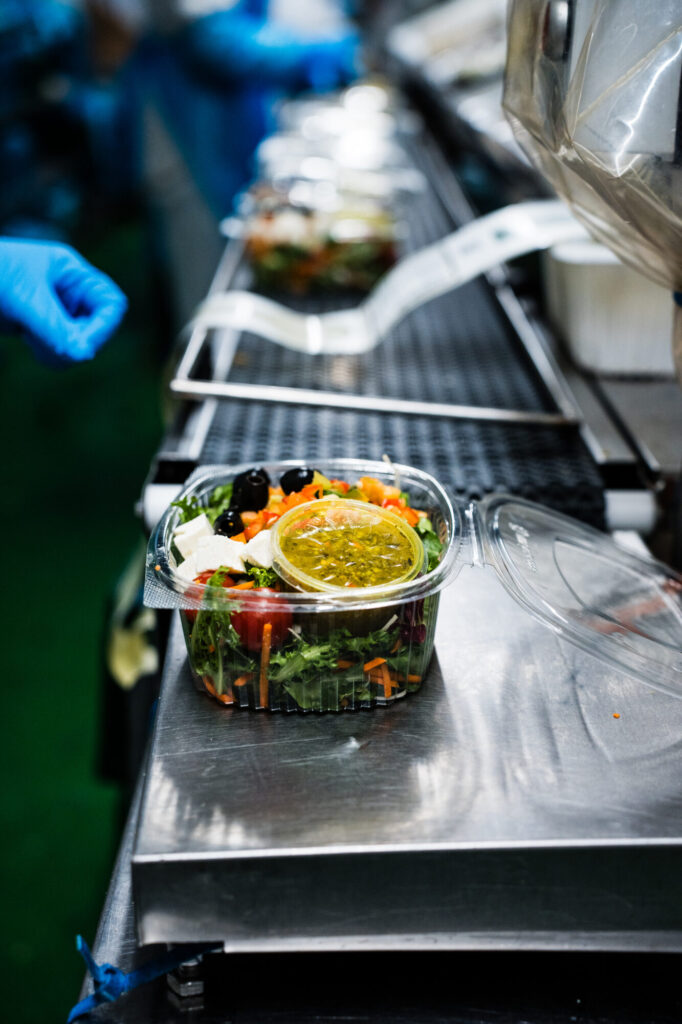 Versiegelte Salatschalen laufen über das Band