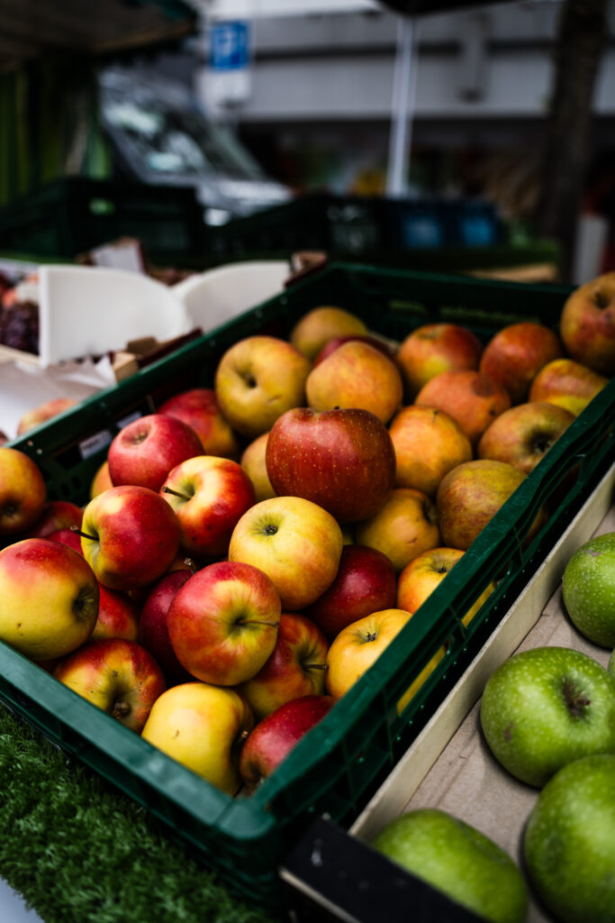 Rote und grüne Äpfel in Kisten am Marktstand